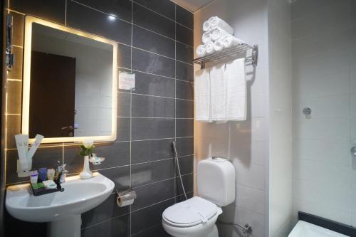 a bathroom with a toilet and a sink and a mirror at Emaar Andalusia in Makkah