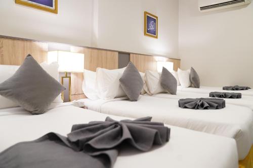 a row of white beds in a room at Emaar Andalusia in Makkah