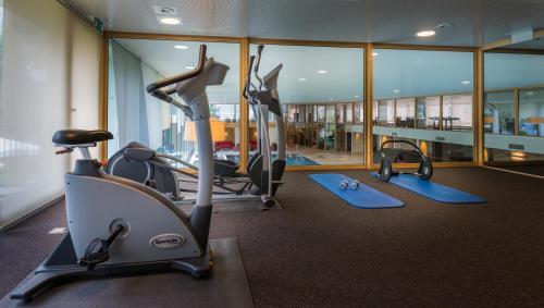 a gym with cardio equipment in a building at The Christiania Mountain & Spa Resort in Zermatt