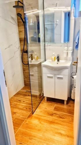 a white bathroom with a shower and a sink at Sunflower Sky Apartment in Rijeka