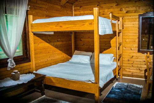a bedroom with two bunk beds in a log cabin at Wooden Village Resort in Ponari