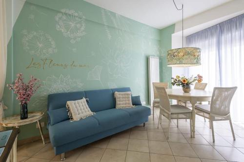 a living room with a blue couch and a table at Trilocale vista spiaggiamare in Diano Marina