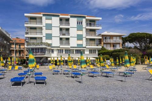 a bunch of chairs and umbrellas in front of a building at Trilocale vista spiaggiamare in Diano Marina