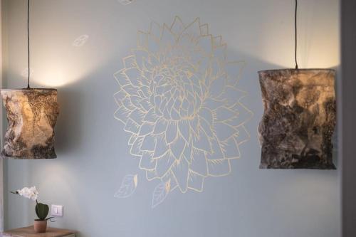 a wall with two lights and a flower on it at Trilocale vista spiaggiamare in Diano Marina