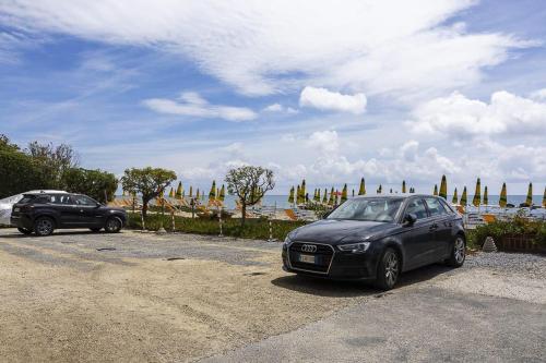 two cars parked in a parking lot near the ocean at Trilocale vista spiaggiamare in Diano Marina