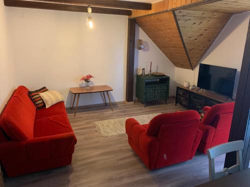 een woonkamer met rode stoelen en een tv bij La Casa del Lago in Siófok