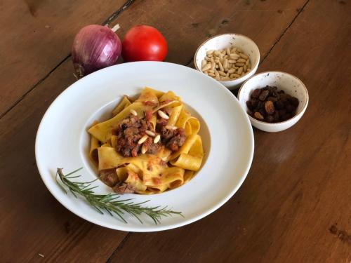 a bowl of pasta on a table with ingredients at Hotel Palazzo San Niccolò & Spa in Radda in Chianti