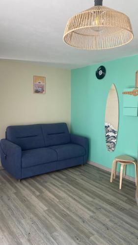 a living room with a blue couch and a mirror at Appartement bord de mer Palavas in Palavas-les-Flots