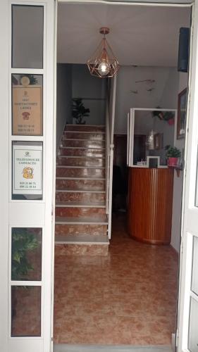 a hallway with stairs and a chandelier at Hostal Buena Vista in Vejer de la Frontera