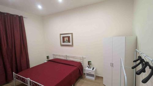 a bedroom with a red bed and a refrigerator at Vititta Apartamet a in Trapani