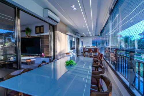 an office with a long glass table and chairs at Mandara Lanai Apartamento Bangalô in Aquiraz
