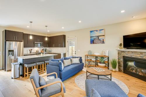a living room with a blue couch and a fireplace at Traverse City Townhome Walk to Boardman Lake! in Traverse City