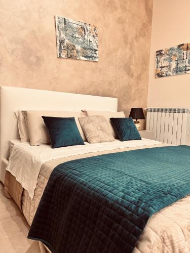 a bedroom with a large bed with blue pillows at Mael Superior Room in Palermo
