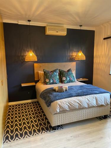 a bedroom with a bed with two lights on it at Paarl Crystal Family Home in Paarl