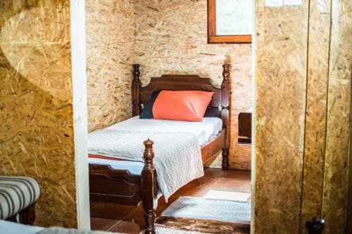 a small bedroom with a bed in a stone wall at Wooden Village Resort in Ponari