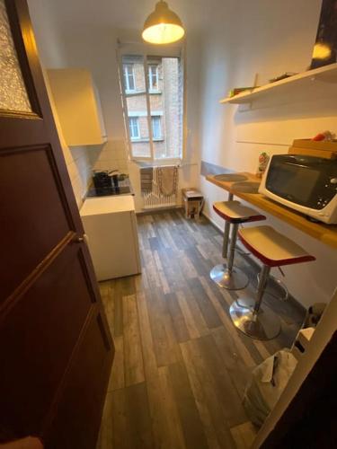 une cuisine avec un comptoir, une table et un tabouret dans l'établissement Charmant T2, Quartier St Georges, à Paris