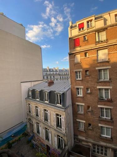 - une vue sur un immeuble depuis une fenêtre dans l'établissement Charmant T2, Quartier St Georges, à Paris