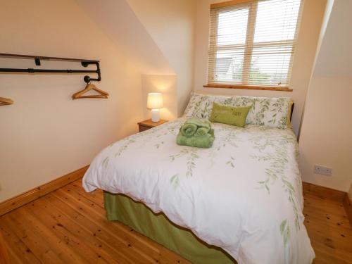 a bedroom with a bed with a green towel on it at 46 Dunalinn in Culdaff