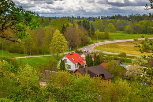 une maison avec un toit rouge sur une route dans l'établissement Saule, à Talsi