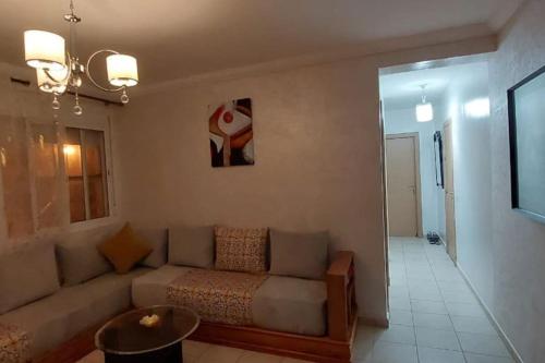 a living room with a couch in a room at Appartement Plage et Bien-être in Fnidek