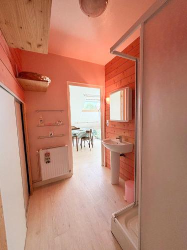 Elle comprend une petite salle de bains pourvue d'un lavabo et d'une table. dans l'établissement Charmante studette au calme avec terrasse et parking, à Auguaise