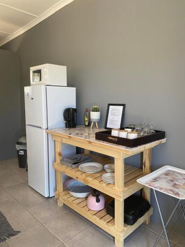 a kitchen with a table and a white refrigerator at Arendsnest in Springbok