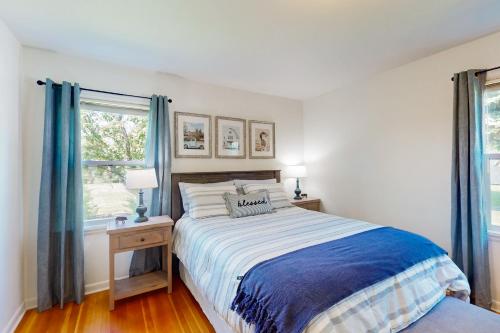 a white bedroom with a bed and two windows at Farmhouse Minus the Farm in East Wenatchee