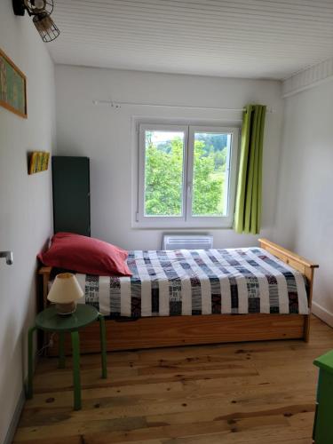 une chambre avec un lit et une fenêtre dans l'établissement Le CHRISOL, au Chambon-sur-Lignon