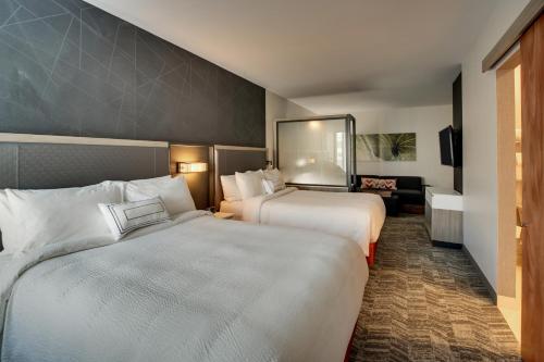 a hotel room with two beds and a television at TownePlace Suites by Marriott Mobile Saraland in Saraland