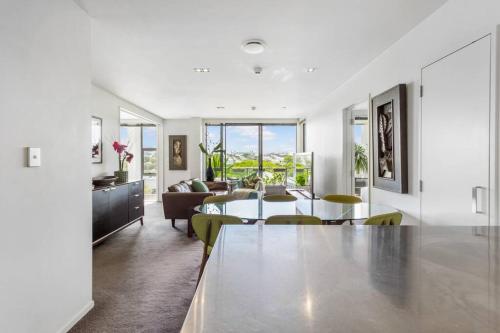 a white living room with a table and chairs at Perfection, Style, 2BR, 2BA, 2 Free Carpark 400m to Eden Park in Auckland