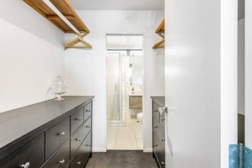 a bathroom with a black dresser and a shower at Perfection, Style, 2BR, 2BA, 2 Free Carpark 400m to Eden Park in Auckland