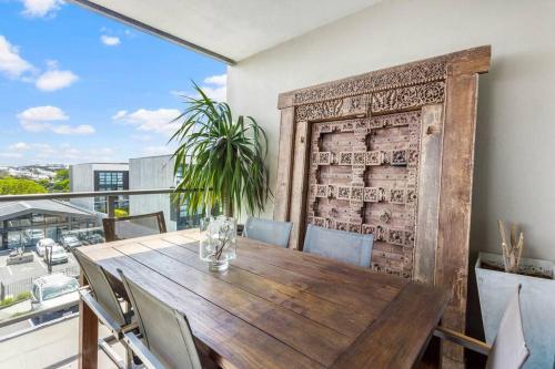 a dining room with a wooden table and chairs at Perfection, Style, 2BR, 2BA, 2 Free Carpark 400m to Eden Park in Auckland