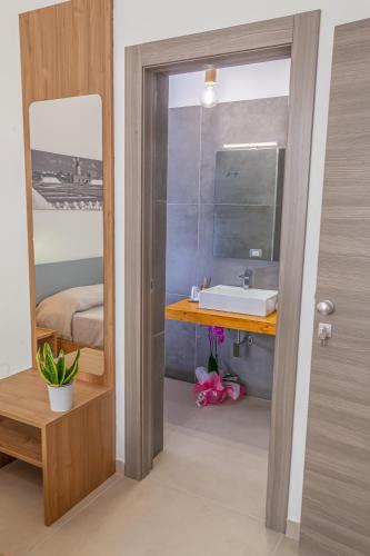 a bathroom with a sink and a mirror at Isgrò Rooms in Marsala