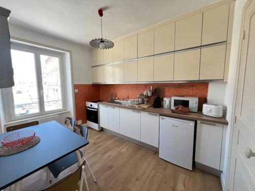 une cuisine avec des placards blancs et un comptoir bleu dans l'établissement Île Beniguet, à Paimpol