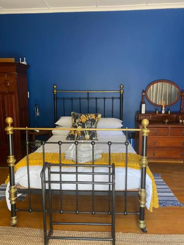a bedroom with a bed with a blue wall at Arendsnest in Springbok