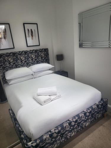 a bedroom with a large bed with white sheets and pillows at Charming Tower Bridge Apartment in London