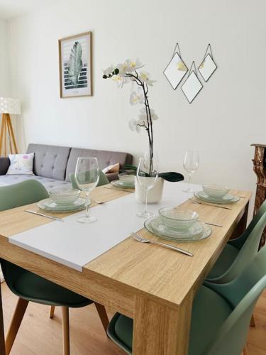 une table en bois avec des assiettes et des verres à vin dessus dans l'établissement Le moderne, à Charleville-Mézières