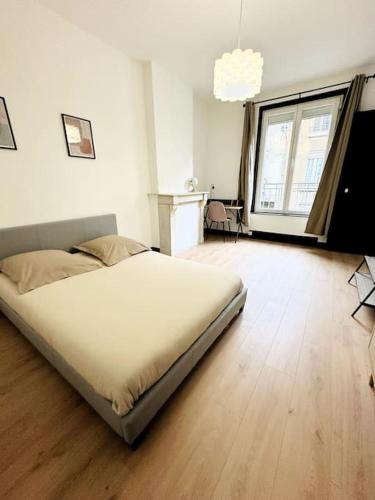 une chambre avec un grand lit et un parquet dans l'établissement Le moderne, à Charleville-Mézières