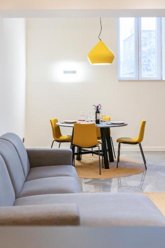 a living room with a couch and a table with chairs at Florette Suite 1BR with Stunning Lounge Terrace by ArcoBnb in Il-Furjana