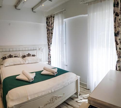 a bedroom with a bed with two pillows on it at Bozcaada Fresh Otel in Canakkale