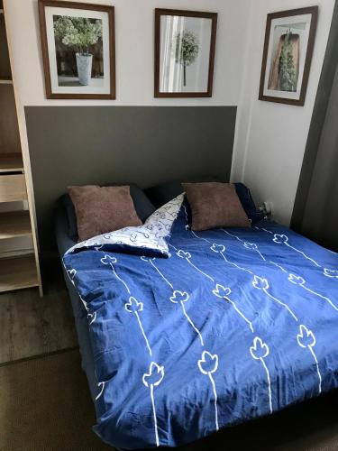 - un lit avec une couette bleue dans une chambre dans l'établissement Marseille Plage, à Marseille