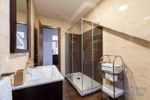 a bathroom with a sink and a glass shower at Casa Eira de Arriba - by entreRías in Cangas de Morrazo