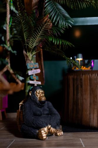 a small statue of a gorilla sitting on a table at Dynasty Jungle Home Spa Jacuzzi in Holtzheim