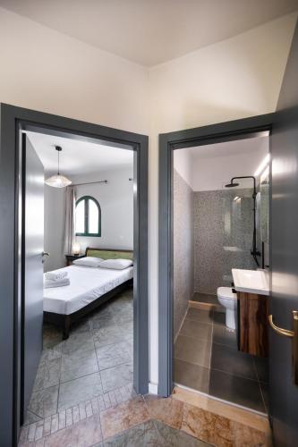 a bedroom with a bed and a bathroom with a sink at AMMOS FAMILY APARTMENTS in Vasiliki