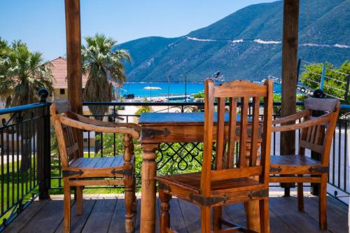 a table and chairs on a porch with a view of the ocean at AMMOS FAMILY APARTMENTS in Vasiliki