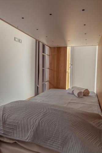 a bedroom with a large bed with two towels on it at Isgrò Rooms in Marsala