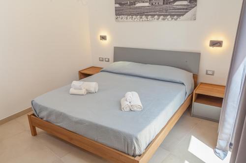 a bedroom with a bed with towels on it at Isgrò Rooms in Marsala