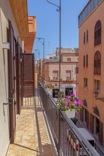a balcony of a building with flowers on it at Isgrò Rooms in Marsala