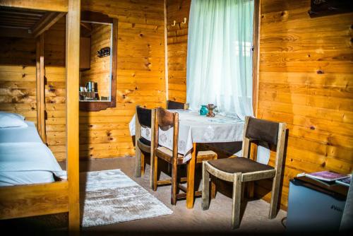 a dining room with a table and chairs in a cabin at Wooden Village Resort in Ponari