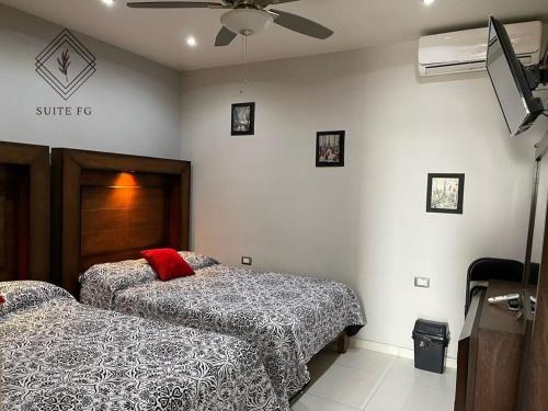 a bedroom with two beds and a ceiling fan at Suite FG in San Juan de los Lagos